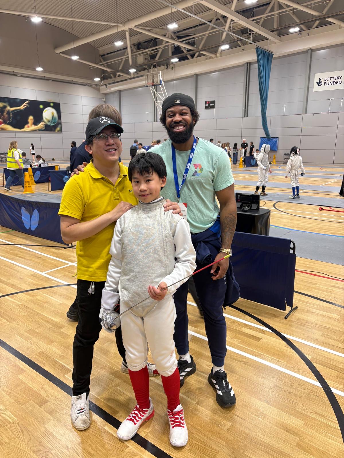 Diamond Blade coaches with young fencer at competition